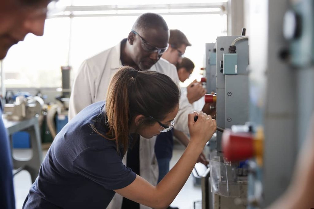 engineer-training-female-apprentice-using-a-drill-2023-11-27-05-11-00-utc